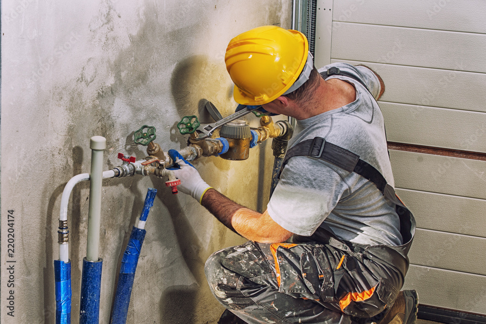 A plumber fitting valves on a water line